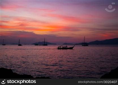 Silhouette Longtail boat with coastal fishing village,Beautiful scenery view in sunset twilight time