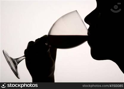 Silhouette man drinking red wine