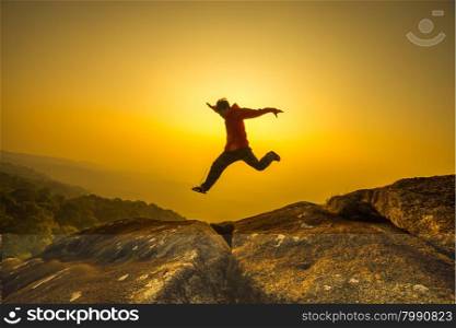 silhouette man jumping into sunset sky