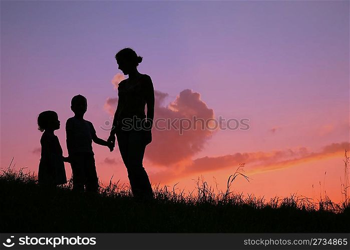 silhouette mother with children on sunset