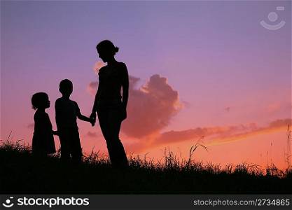 silhouette mother with children on sunset