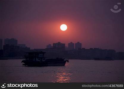 Silhouette of a boat in a river, Shamian Island, Guangzhou, Guangdong Province, China