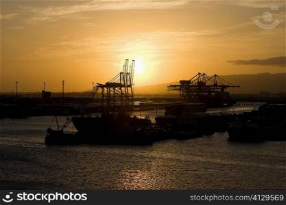 Silhouette of a container ship and cranes at a commercial dock