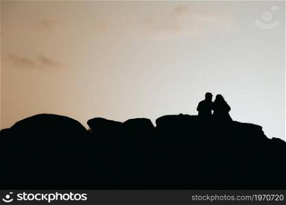 Silhouette of a couple over a colorful sunset during a sunny day