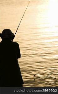 Silhouette of a father and his son fishing