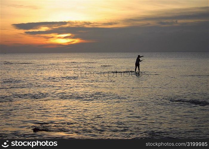 Silhouette of a fisherman fishing in the sea, Ko Lanta, Thailand