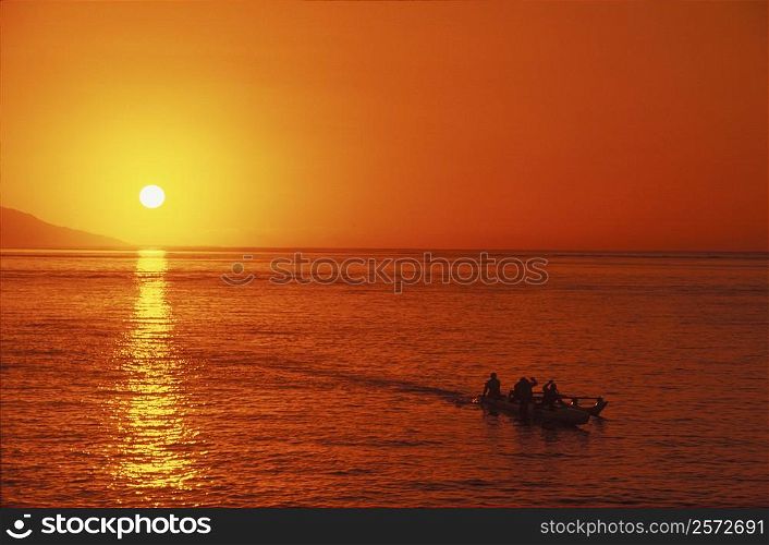 Silhouette of a group of people on a boat in the ocean, Hawaii, USA