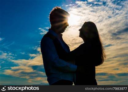 silhouette of a loving couple hugging at sunset