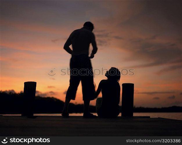 Silhouette of a man and a woman on a pier