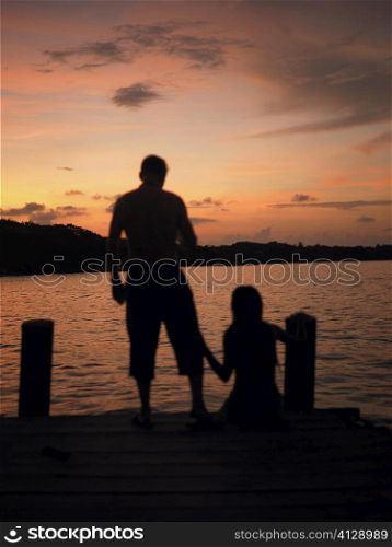 Silhouette of a man and a woman on a pier