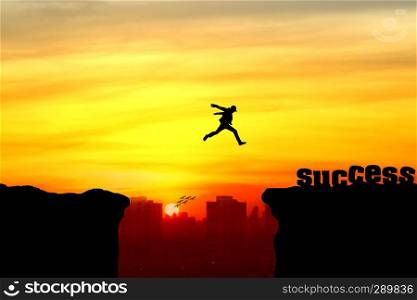 Silhouette of a man jumping over the cliff, jump go on to success