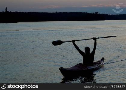 Silhouette of a man kayaking in a lake, Lake of the Woods, Ontario, Canada