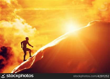 Silhouette of a man running up hill to the peak of the mountain. Trekking, active lifestyle, motivation, strength