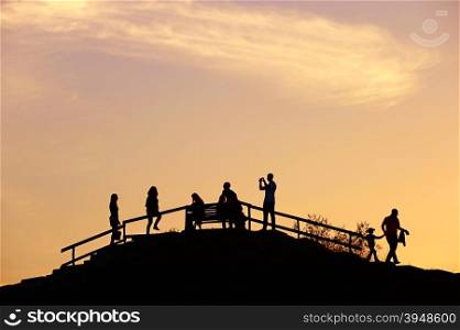 Silhouette of a people on a hill viewpoint at sunset