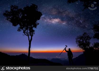 Silhouette of a Professional photographer who shooting a milky way on mountain