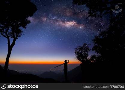 Silhouette of a Professional photographer who shooting a milky way on mountain