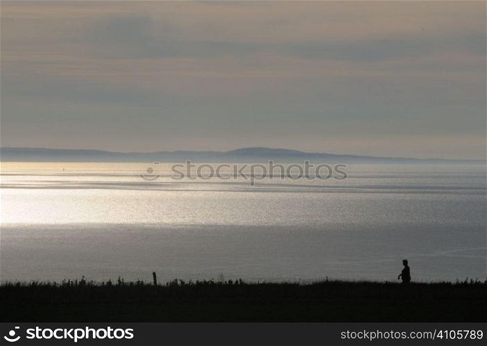Silhouette of a rambler by the sea