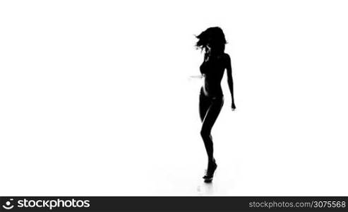 Silhouette of a sexy woman with long hair in high heels dancing isolated on white