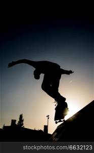 Silhouette of a Skater riding the skate in a half pipe in a skate park in lisbon