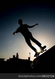 Silhouette of a Skater riding the skate in a half pipe in a skate park in lisbon