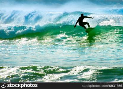 Silhouette of a surfer riding a wave in the ocean