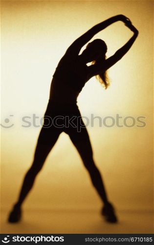 Silhouette of a woman exercising