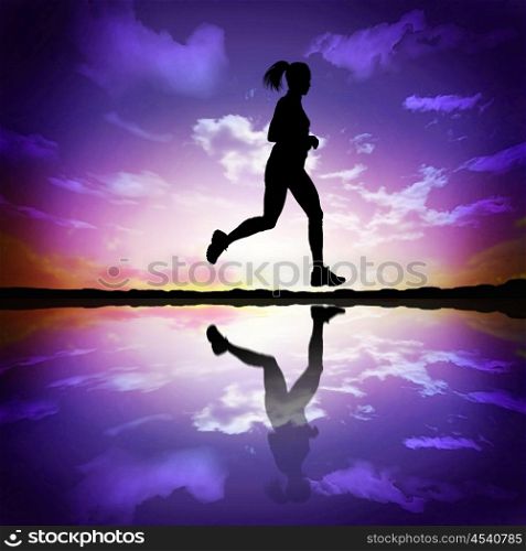 Silhouette of a woman running against the evening sky