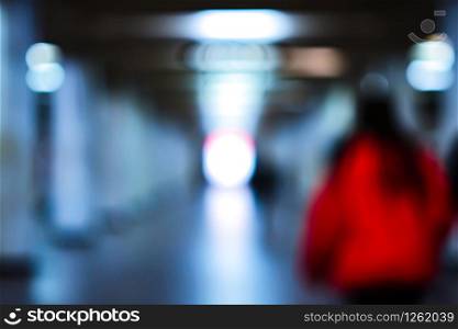Silhouette of a young attractive lady in red in blur. Blurry image of people moving to light