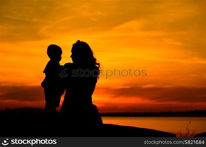 Silhouette of a young mother with her little baby