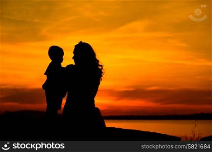 Silhouette of a young mother with her little baby