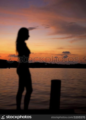 Silhouette of a young woman by the sea