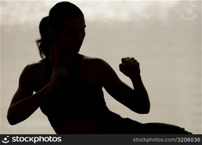 Silhouette of a young woman exercising