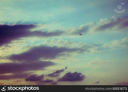 Silhouette of an airplane flying in sunset sky.