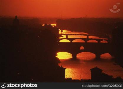 Silhouette of an arch bridge across a river, Ponte Vecchio, Arno River, Florence, Tuscany, Italy