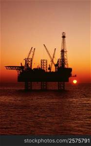Silhouette of an oil drilling rig at dusk, Mediterranean Sea, Tunisia