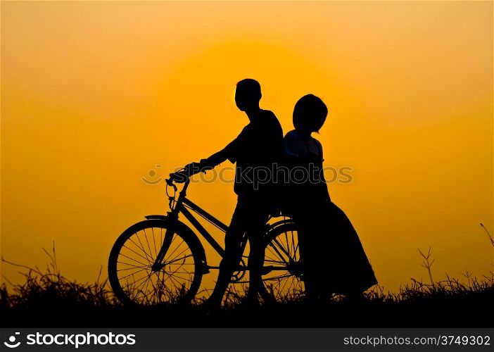 silhouette of boy and girl happy with bicycle