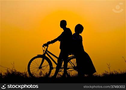 silhouette of boy and girl happy with bicycle