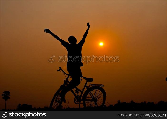 silhouette of boy happy with bicycle