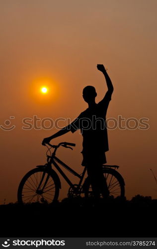 silhouette of boy happy with bicycle