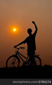 silhouette of boy happy with bicycle