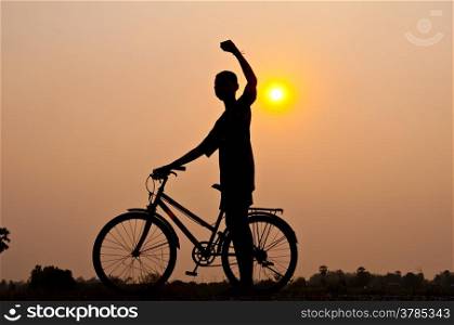 silhouette of boy happy with bicycle
