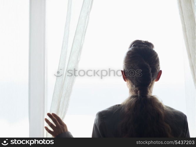 Silhouette of business woman looking into window