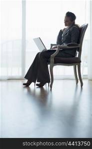 Silhouette of business woman working on laptop