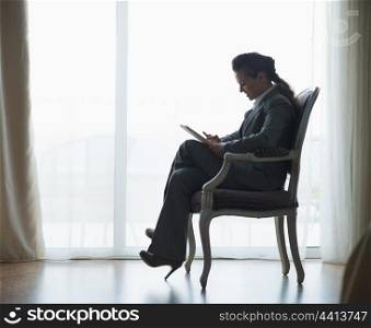 Silhouette of business woman working on tablet pc