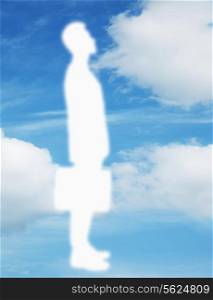 Silhouette of businessman holding a briefcase with a blue sky and clouds behind him