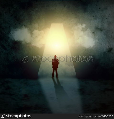 Silhouette of businessman in keyhole. Silhouette of businessman standing in keyhole sun shining above