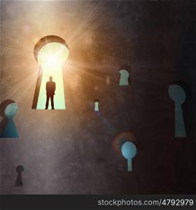 Silhouette of businessman in keyhole. Silhouette of businessman standing in keyhole sun shining above