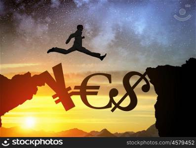 Silhouette of businessman over sunrise. Businessman running on currency signs over precipice