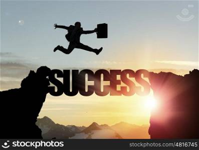 Silhouette of businessman over sunrise. Businessman running on success word bridge over precipice