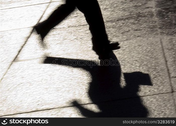 Silhouette of businessman running downtown.